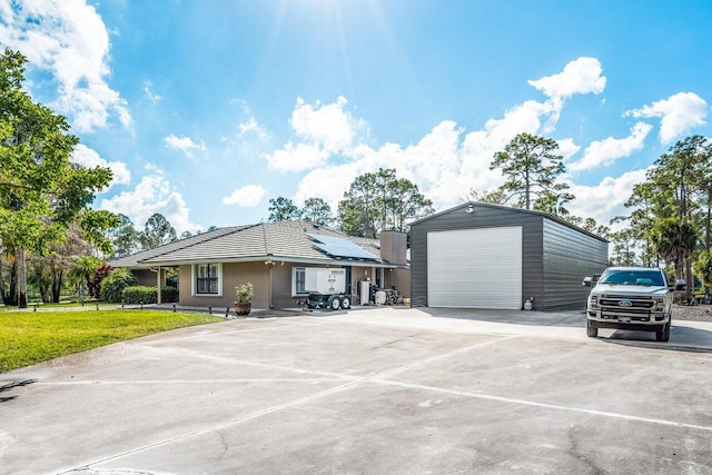 view of front of home with a front lawn, a garage, and solar panels