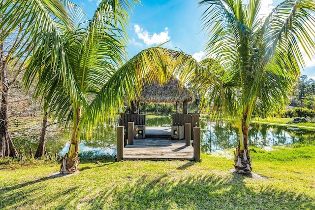 surrounding community featuring a yard, a boat dock, and a water view