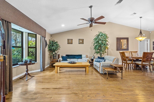 living room featuring light hardwood / wood-style floors, vaulted ceiling, and ceiling fan