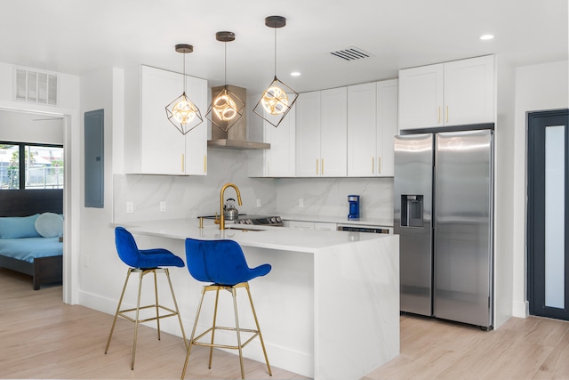 kitchen with light hardwood / wood-style floors, backsplash, white cabinetry, and stainless steel refrigerator with ice dispenser