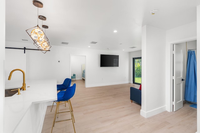 dining room with a barn door and light hardwood / wood-style flooring