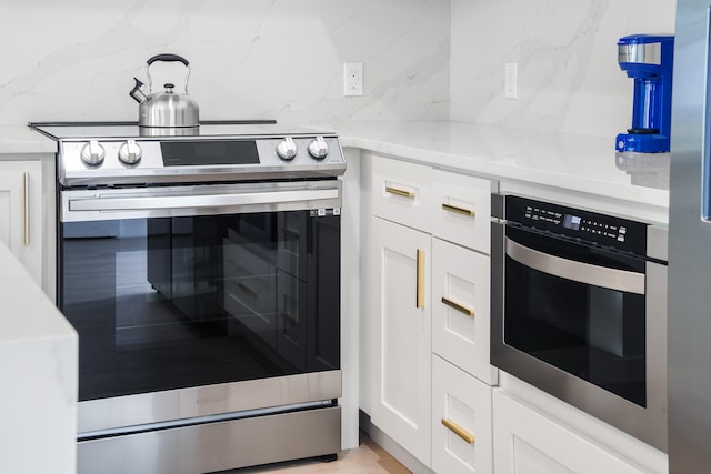 kitchen featuring decorative light fixtures, white cabinets, backsplash, and appliances with stainless steel finishes