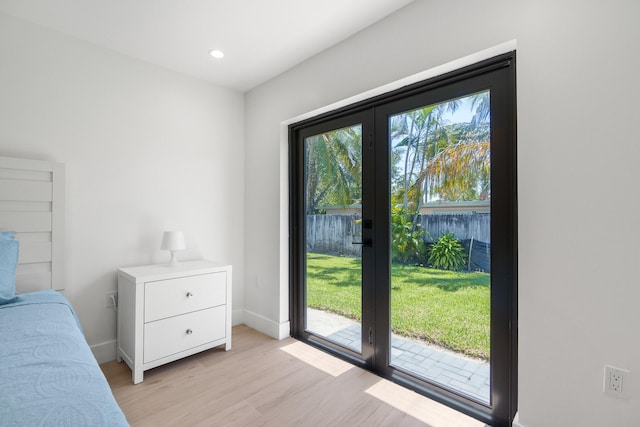 unfurnished bedroom with multiple windows, french doors, light wood-type flooring, and access to outside