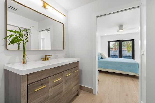 bathroom with ceiling fan, french doors, hardwood / wood-style flooring, and vanity