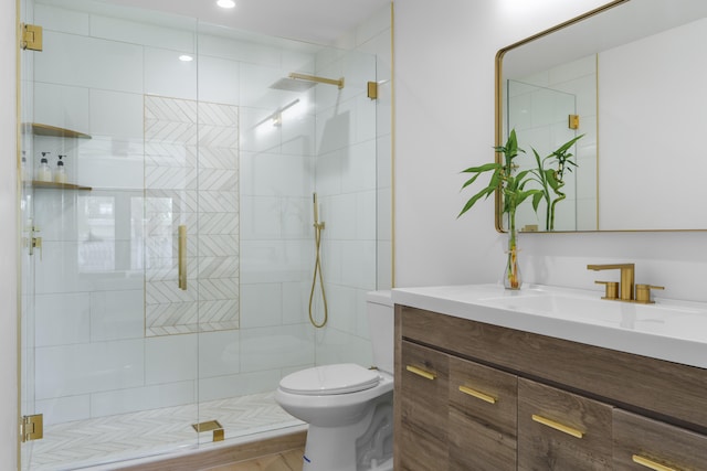 bathroom featuring a shower with shower door, toilet, and vanity