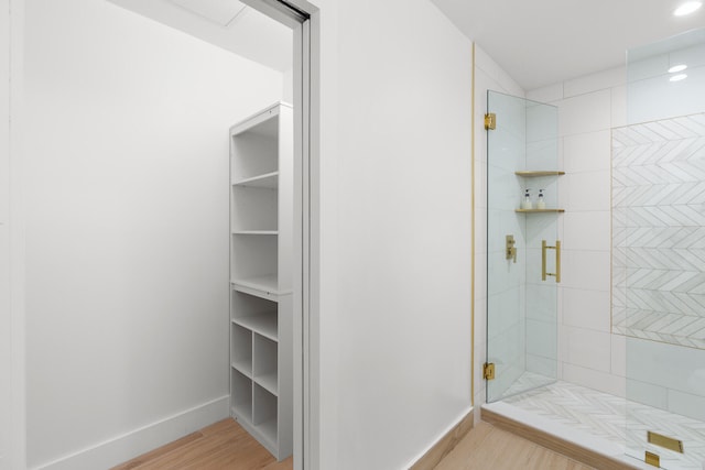 bathroom featuring a shower with shower door and hardwood / wood-style floors