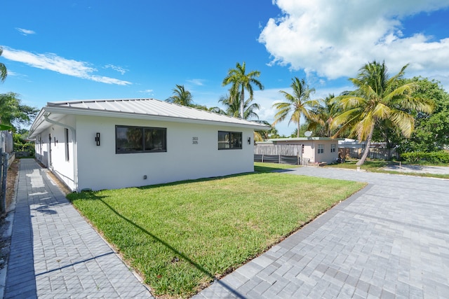 view of side of home with a yard