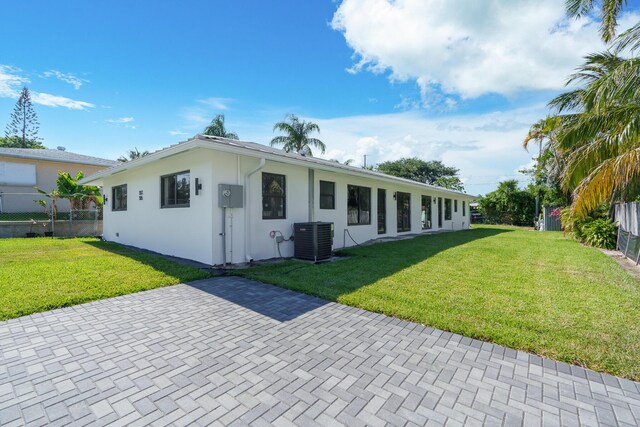 ranch-style house with a patio, central AC unit, and a front lawn