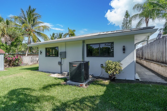 back of property with a lawn and central AC unit