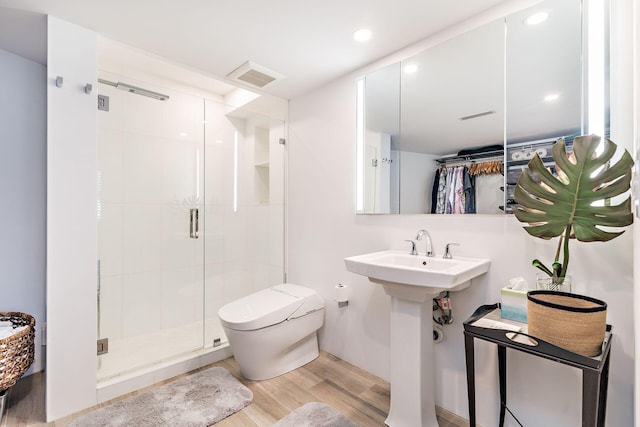 bathroom featuring a shower with door, toilet, wood-type flooring, and sink