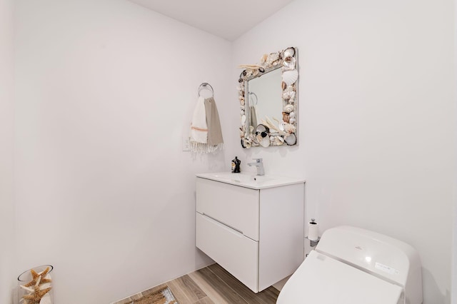 bathroom featuring wood-type flooring, toilet, and vanity