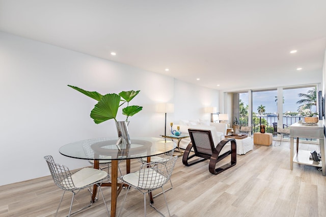 dining area featuring expansive windows, light hardwood / wood-style floors, and french doors