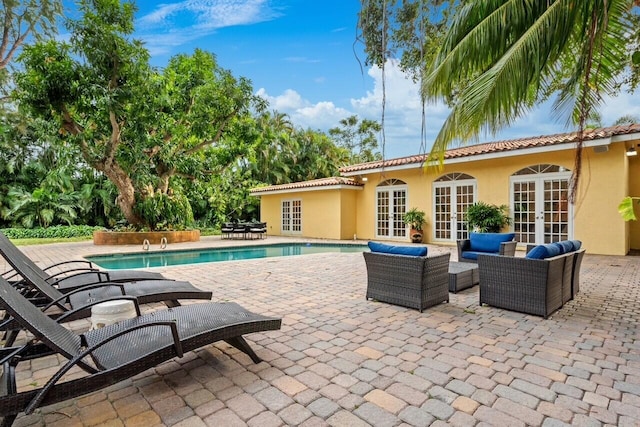 view of pool featuring a patio area, outdoor lounge area, and french doors