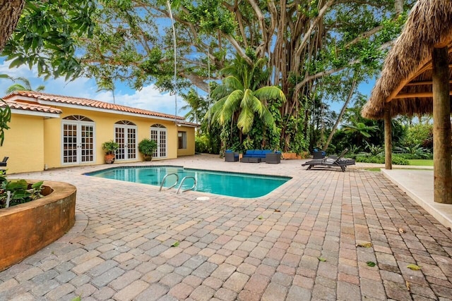 view of pool featuring an outdoor living space, french doors, and a patio