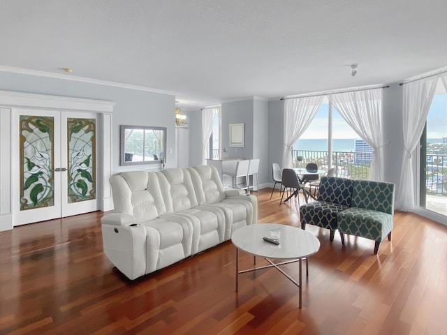 living area with a healthy amount of sunlight, crown molding, and wood finished floors