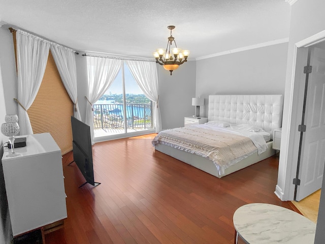 bedroom featuring access to exterior, wood-type flooring, a notable chandelier, and ornamental molding