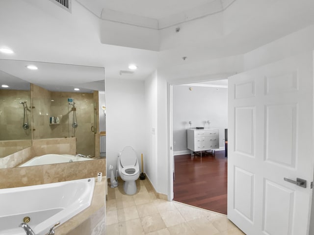 bathroom with recessed lighting, toilet, a stall shower, baseboards, and a bath