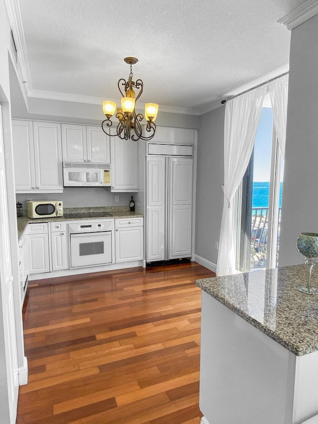 kitchen featuring a chandelier, white appliances, white cabinetry, and crown molding