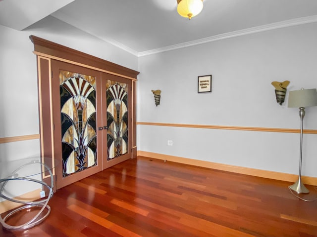 unfurnished room featuring french doors, crown molding, baseboards, and wood finished floors