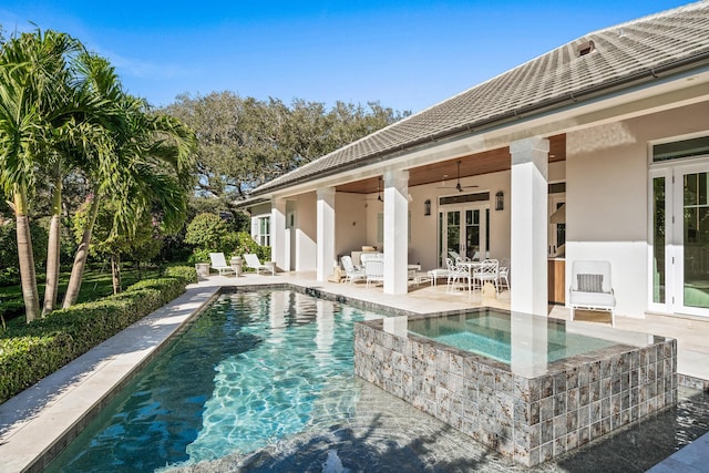 view of swimming pool with an in ground hot tub, ceiling fan, a patio, and french doors