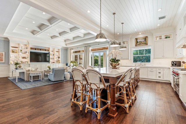 dining area featuring sink, crown molding, coffered ceiling, dark hardwood / wood-style flooring, and beamed ceiling