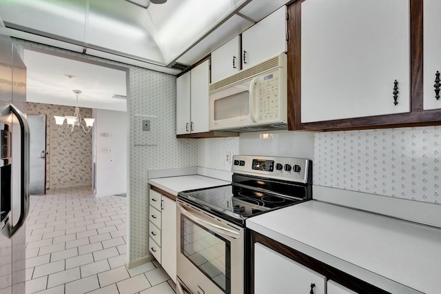 kitchen with light tile patterned flooring, white cabinetry, a chandelier, stainless steel electric range, and pendant lighting