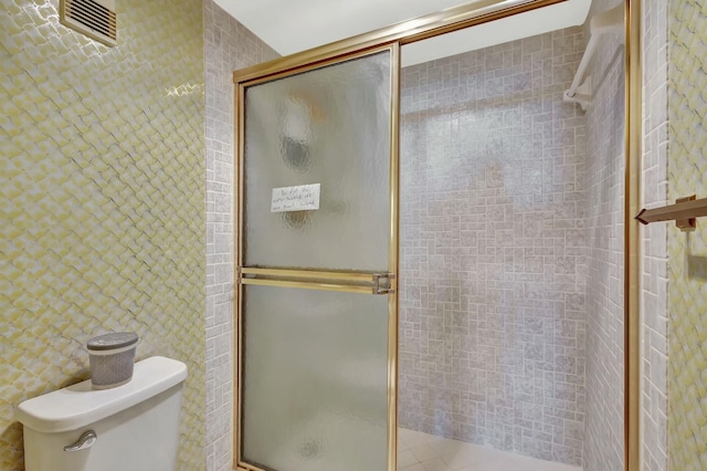 bathroom with toilet and an enclosed shower