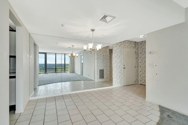 tiled spare room featuring a notable chandelier