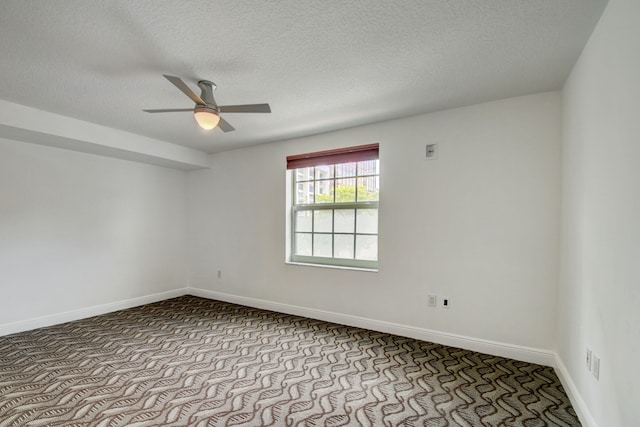 carpeted empty room featuring ceiling fan and a textured ceiling