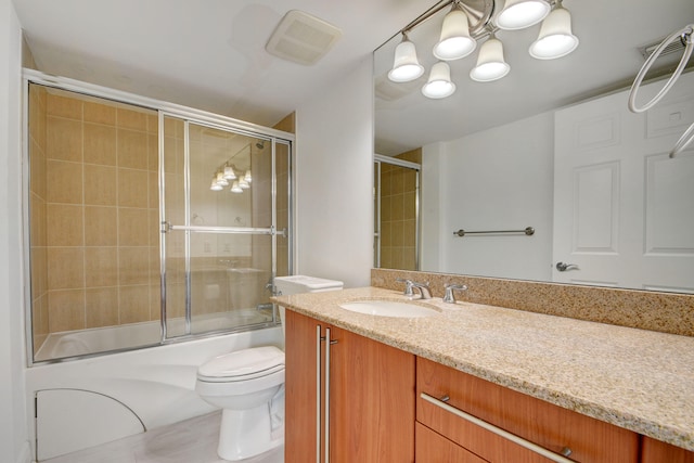 full bathroom with vanity, shower / bath combination with glass door, and toilet