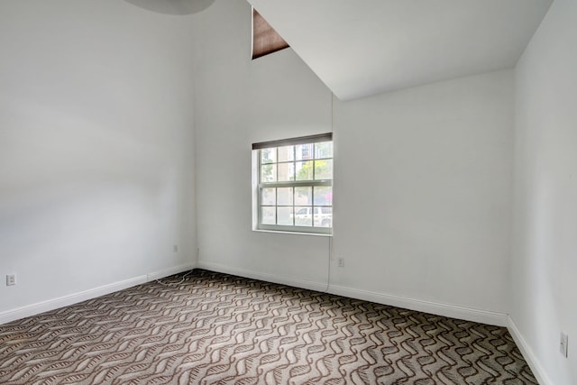 unfurnished room featuring light carpet and vaulted ceiling