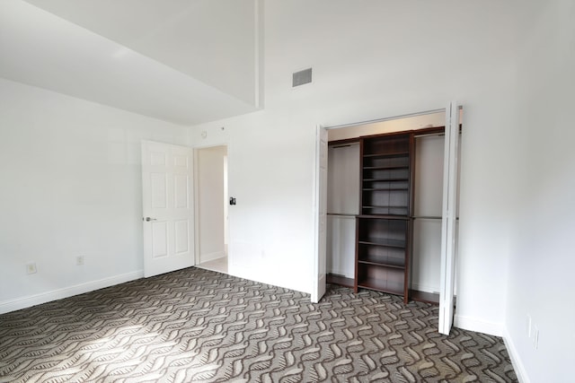 unfurnished bedroom featuring a closet and a high ceiling