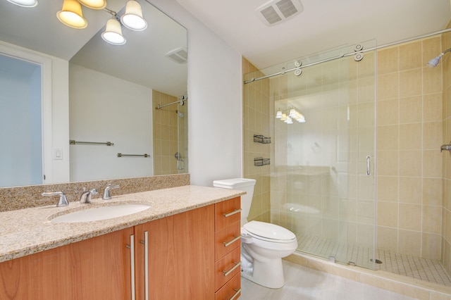 bathroom with vanity, toilet, and a shower with shower door