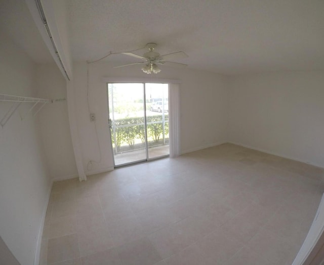 tiled spare room with ceiling fan