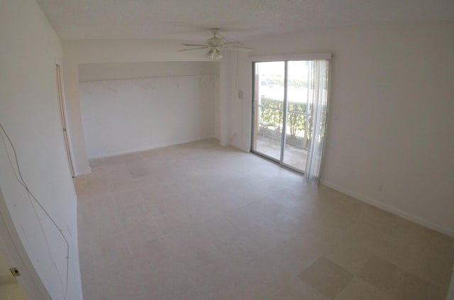 spare room featuring a textured ceiling, ceiling fan, and light tile floors