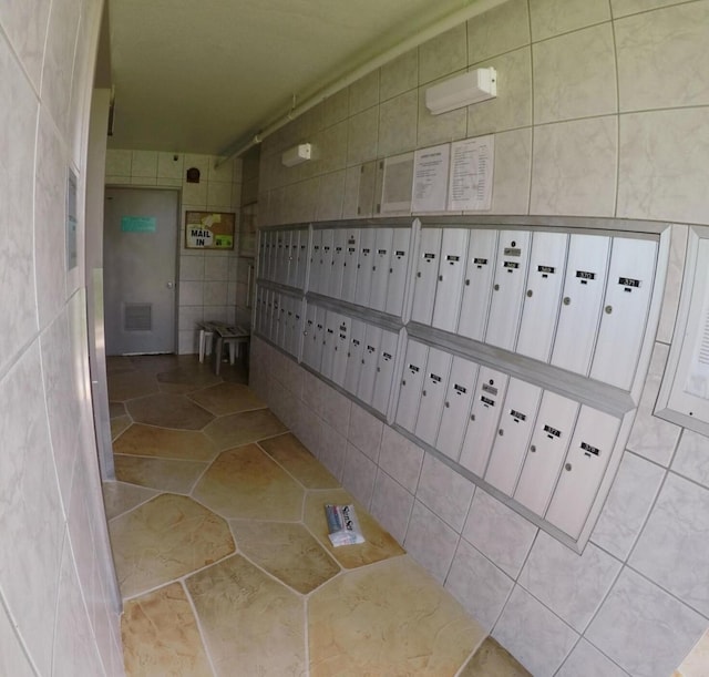 bathroom featuring tile walls, a mail area, and tile floors