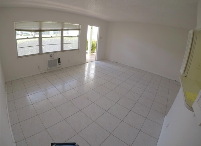 tiled spare room with a wall unit AC