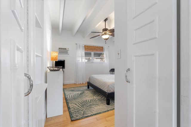 bedroom with ceiling fan, beam ceiling, hardwood / wood-style floors, and an AC wall unit