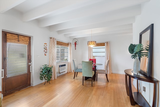 dining room featuring a healthy amount of sunlight, light hardwood / wood-style flooring, a wall mounted AC, and beamed ceiling