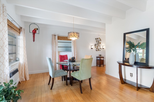 dining area featuring beamed ceiling, an AC wall unit, and light hardwood / wood-style floors