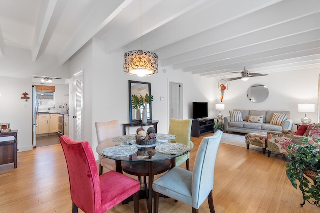 dining area featuring beamed ceiling, ceiling fan, and light wood-type flooring