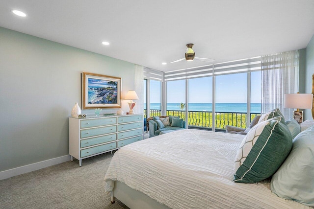 carpeted bedroom featuring a water view, ceiling fan, access to outside, and multiple windows