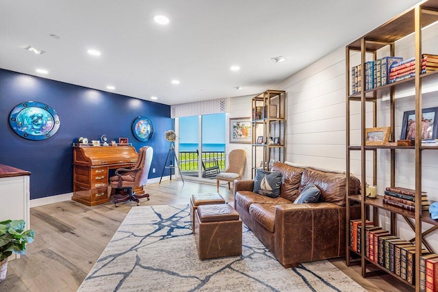 living room featuring light hardwood / wood-style floors and a water view