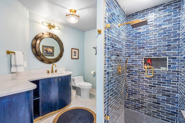 bathroom featuring vanity, toilet, and tiled shower