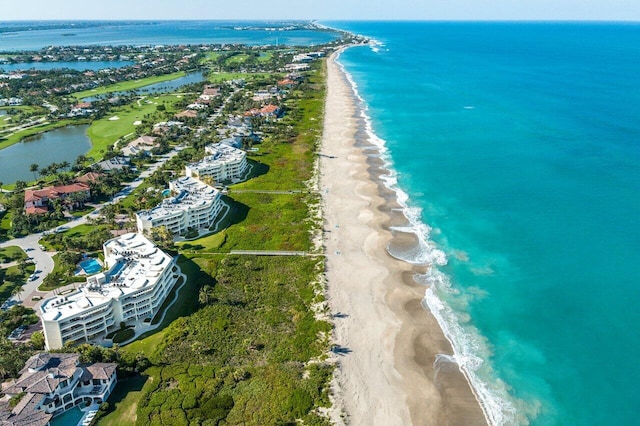 birds eye view of property with a water view and a beach view