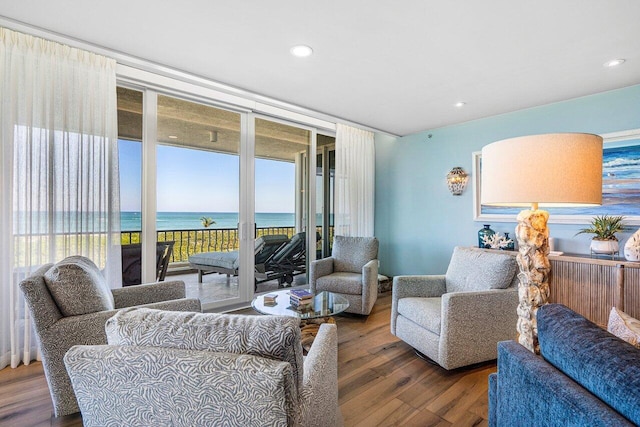 living room featuring a water view and dark hardwood / wood-style flooring