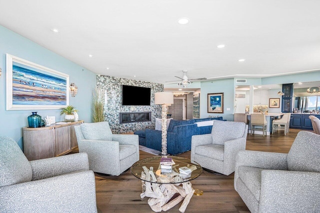 living room featuring ceiling fan and dark hardwood / wood-style flooring