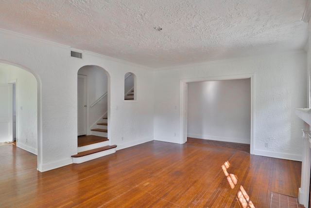 empty room with a textured ceiling and dark hardwood / wood-style floors