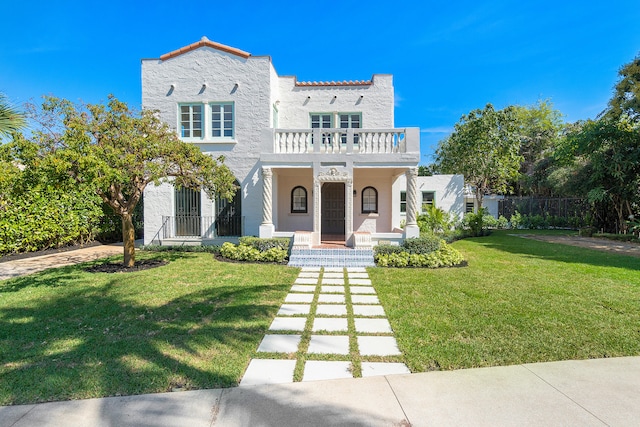 mediterranean / spanish-style house with a porch, a balcony, and a front yard