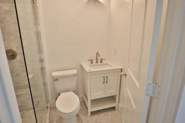 bathroom featuring vanity, toilet, and a shower with door